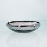 Flat round grey glass bowl with metal interior coating and splashes. Designer glass fruit bowl with mirror effect.