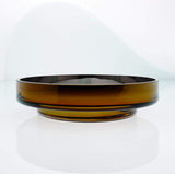 Large, flat disk glass fruit bowl in amber with metal interior coating. Designer hand made glass bowl.