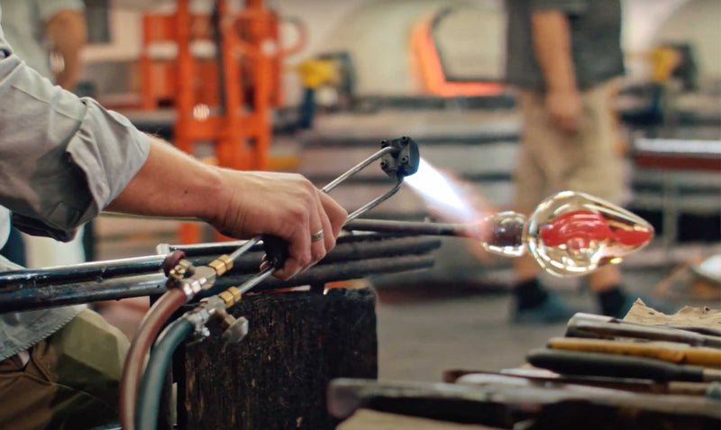hand blowing glass for bowls and vases. Glass artistry, mouth blown glass.