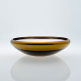 Flat round amber glass bowl with metal interior coating. Designer glass fruit bowl with mirror effect.