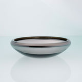 Flat round grey glass bowl with metal interior coating. Designer glass fruit bowl with mirror effect.
