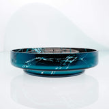 Large, flat disk glass fruit bowl in teal blue with metal interior coating and splashes. Designer hand made glass bowl.